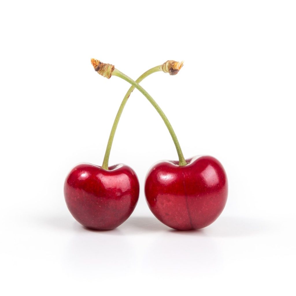 two cherries on white surface